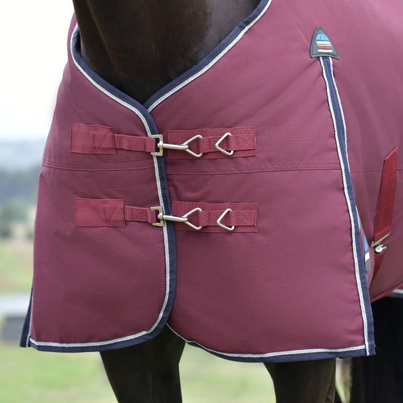 Close-up of a Weatherbeeta Comfitec Essential 50g Burgundy/Navy rug with metal buckles on horse.