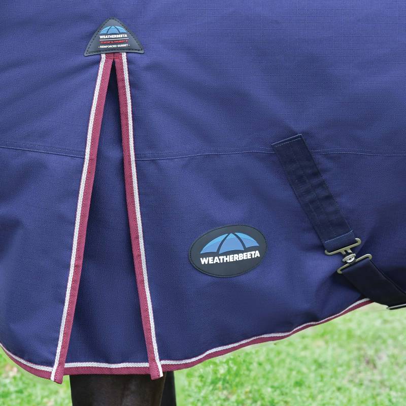 Close-up of a navy/burgundy Weatherbeeta Comfitec Essential turnout rug outdoors.
