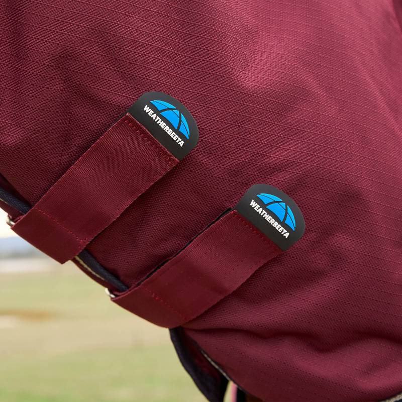 Close-up of maroon straps with Weatherbeeta logos on a ComFiTec Prelim Combo Turnout Rug.