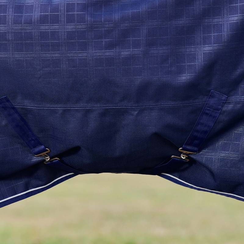 Close-up of Weatherbeeta Comfitec 220g navy plaid turnout rug with straps and metal clips.