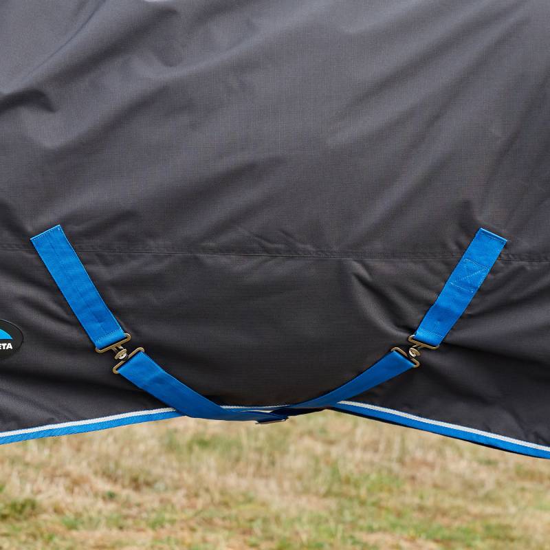 Close-up of a black/cobalt Weatherbeeta Comfitec Tyro Combo Neck Turnout Rug 220g on grass.