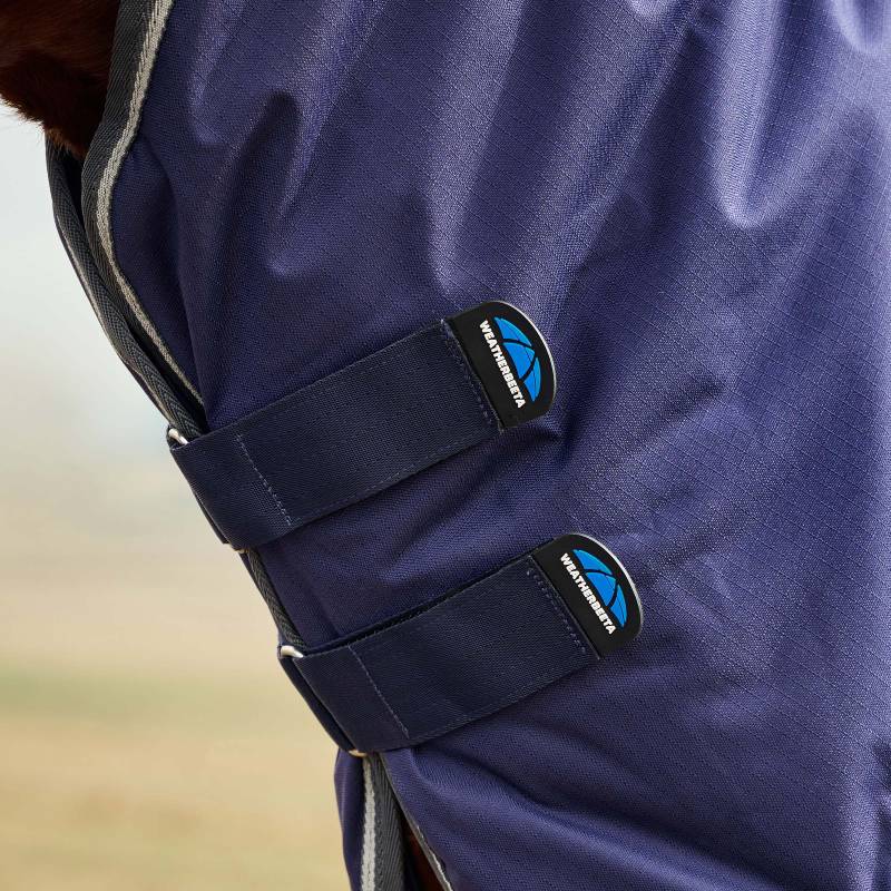 Close-up of Weatherbeeta Comfitec Tyro Rug fastened with two velcro straps and blue logos.