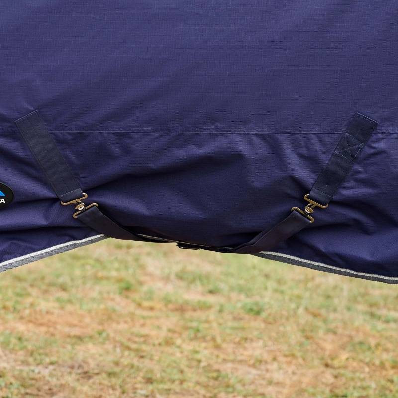Close-up of a Weatherbeeta Comfitec Tyro Turnout Rug Standard Neck 220g Navy/Charcoal on grass.
