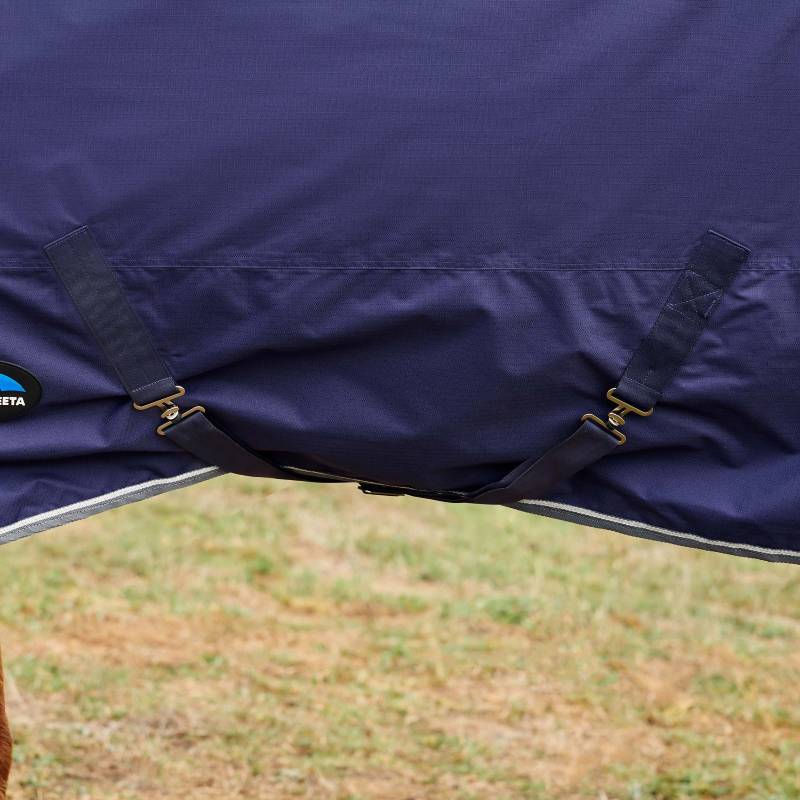 Weatherbeeta ComFiTec Tyro Turnout Rug 50g Navy/Charcoal on horse standing on grass.