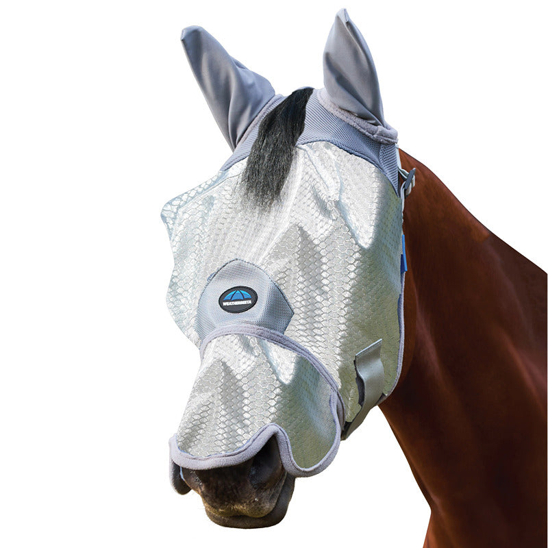 A horse outdoors wears the Weatherbeeta Comfitec Hexi Shield Fly Mask With Ears & Nose Silver.