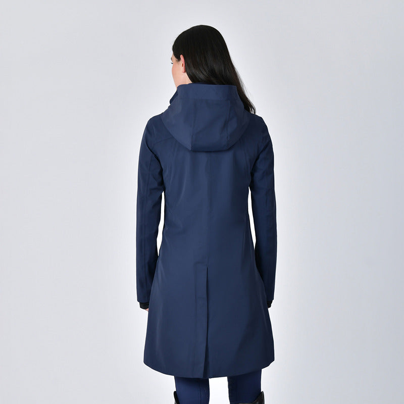 Woman in Weatherbeeta Protect Waterproof Longline Riding Jacket Navy stands against a light background.
