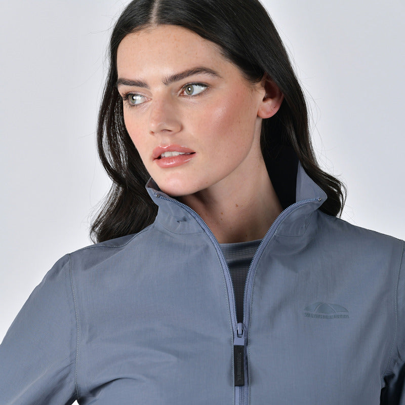 Woman in a Weatherbeeta Waterproof Team Jacket Slate Blue, looking to the side.