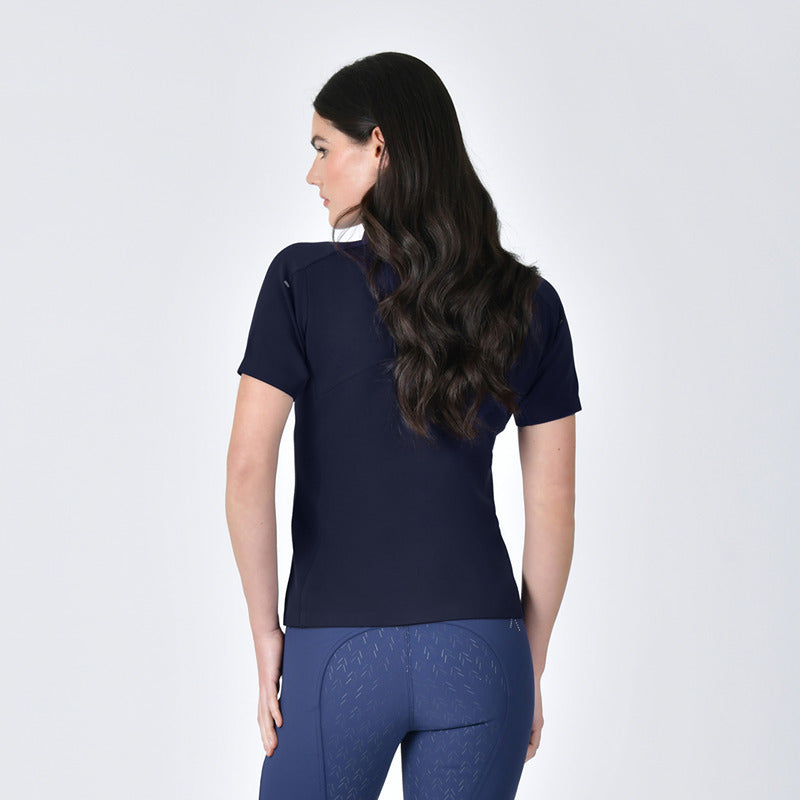 Woman with long wavy hair wears a Weatherbeeta 37.5 Navy Performance Polo, facing away.