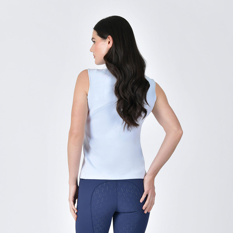 Woman in a Weatherbeeta 37.5 Sleeveless Performance Polo Mist Blue and navy pants on white.
