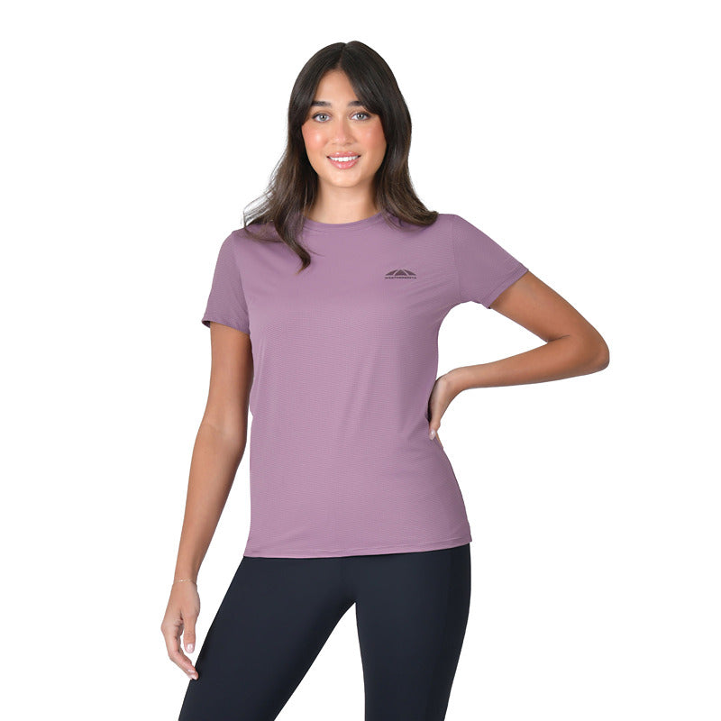 Woman in a Weatherbeeta mauve tee and black leggings stands with one hand on her hip.