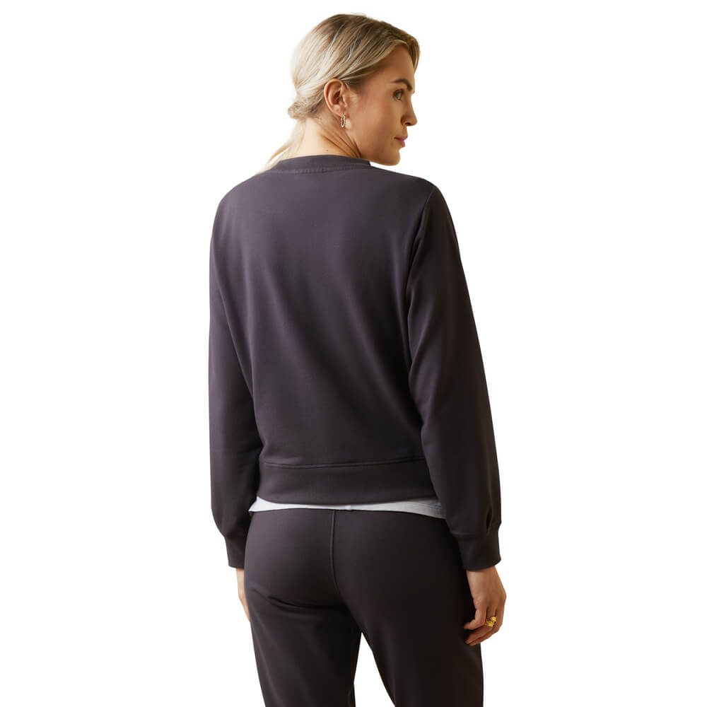 Woman in an Ariat Womens Memento Sweatshirt Periscope stands with her back to a white background.