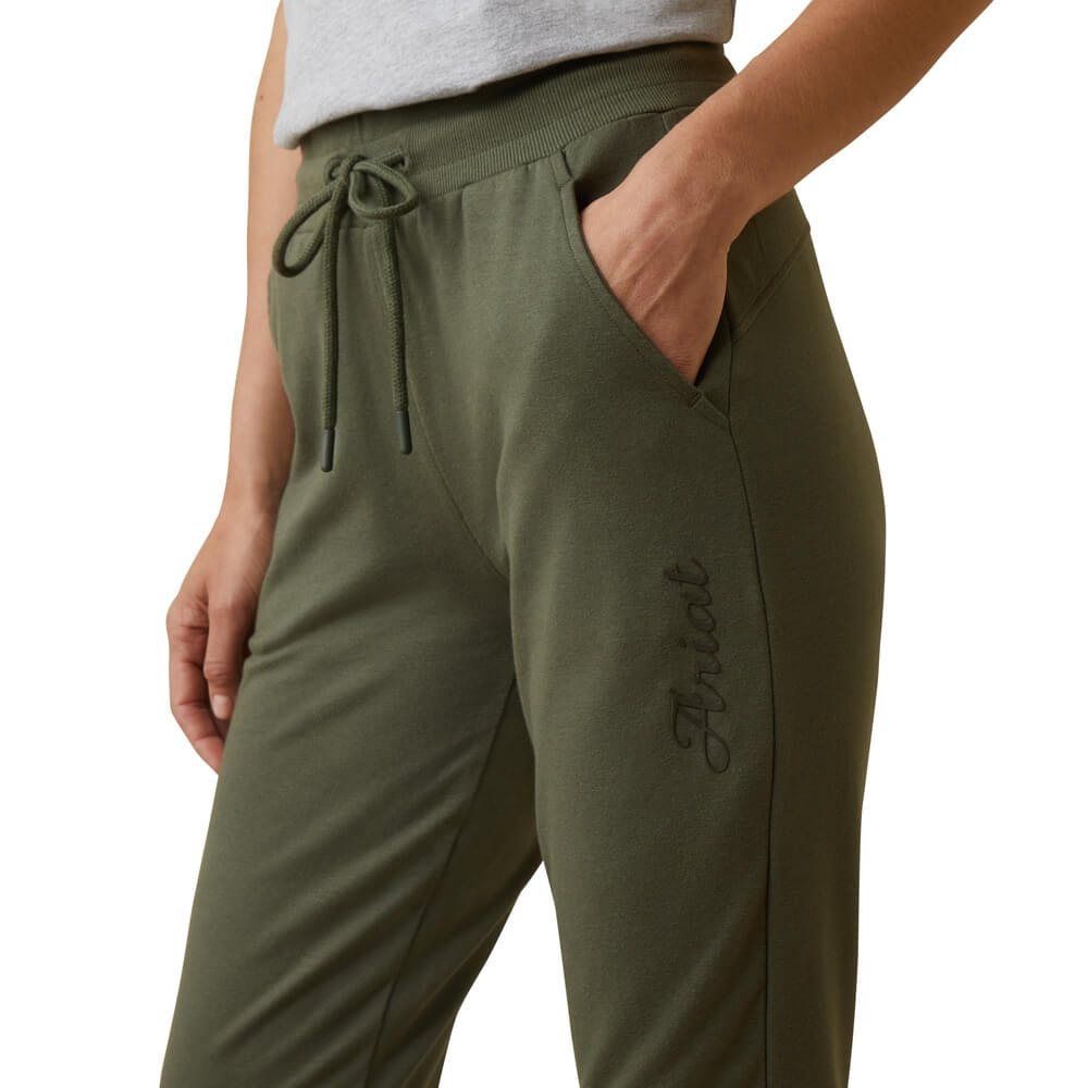 Person wearing Ariat Womens Memento Jogger Beetle pants with a drawstring and hand in pocket.