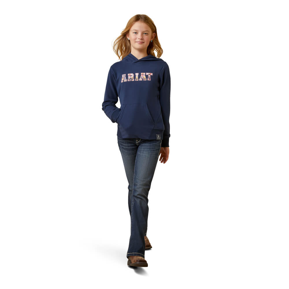 Girl in Ariat Youth 3D Logo 2.0 Hoodie Navy/Red and jeans, walking on white background.
