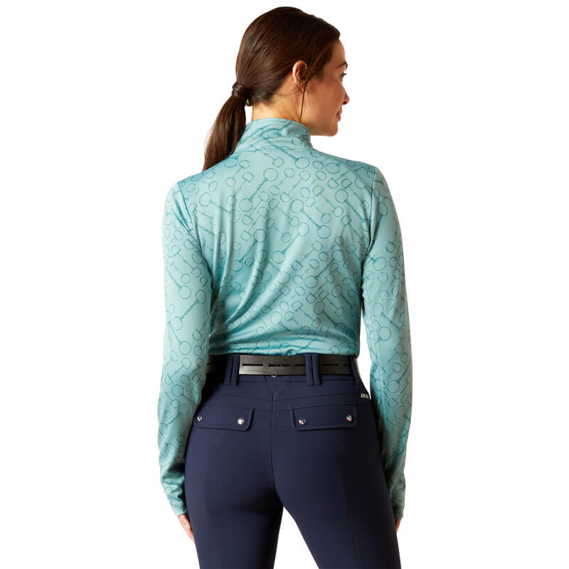 Woman in an Ariat Womens Prophecy 1/4 Zip Arctic top and navy pants, seen from the back.