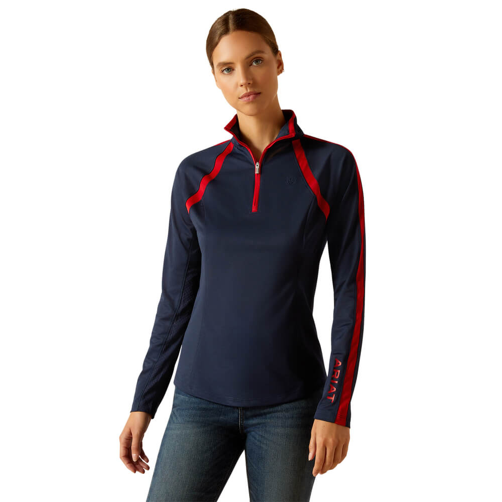 Woman in navy/red Ariat Womens Sunstopper 3.0 Baselayer and jeans, white background.