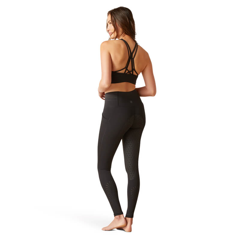 Woman in black Ariat Womens Eos 2.0 FS Tight, barefoot, looking over her shoulder.