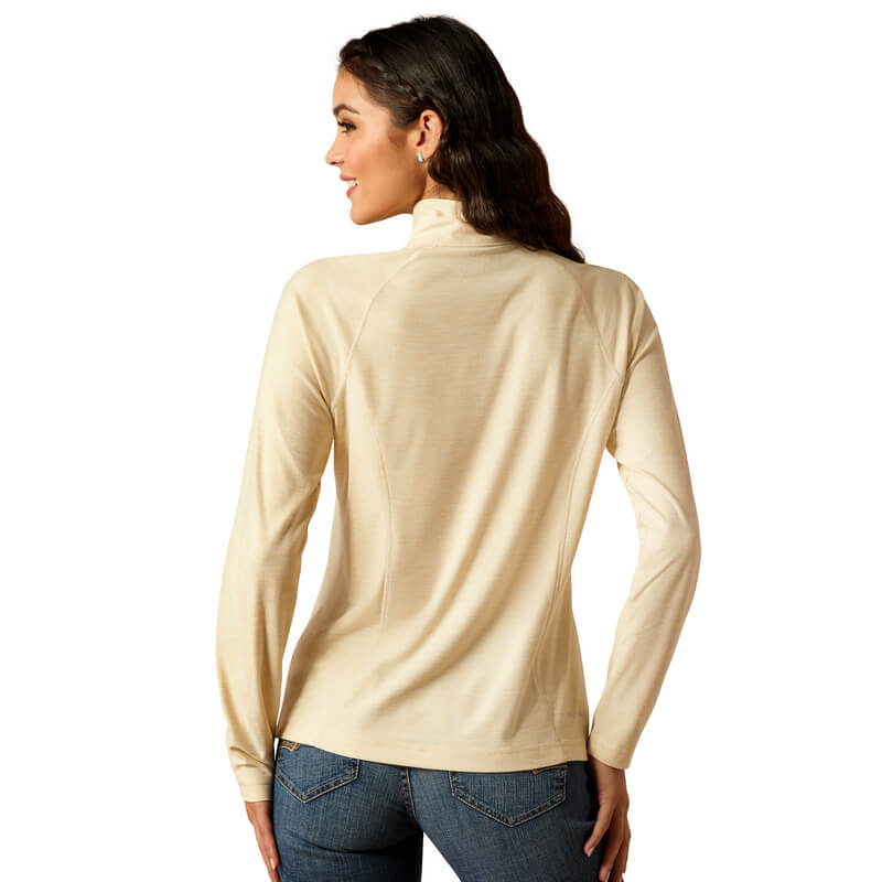 Woman with wavy hair in a beige Ariat Laguna 2.0 ¼ Zip Top Summer Sand, seen from behind.