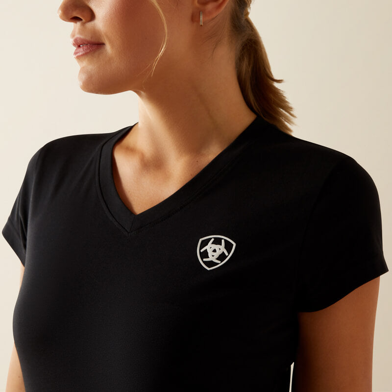 Woman wears Ariat Womens BV Logo T-Shirt Black, featuring a white logo and organic cotton.