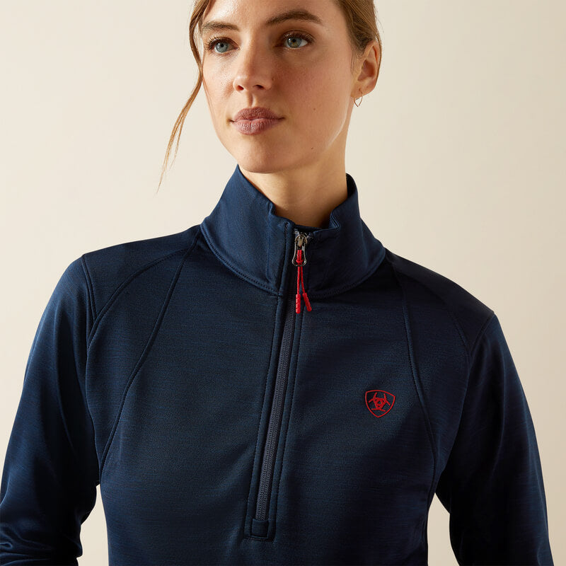 Woman in Ariat Womens Team EQ 1/2 Zip Pullover Navy by Ariat, looking down and smiling.