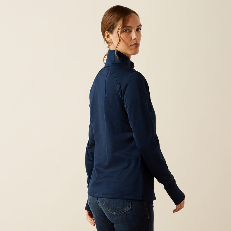Woman in an Ariat Womens Team EQ 1/2 Zip Pullover Navy and jeans, looking over her shoulder.