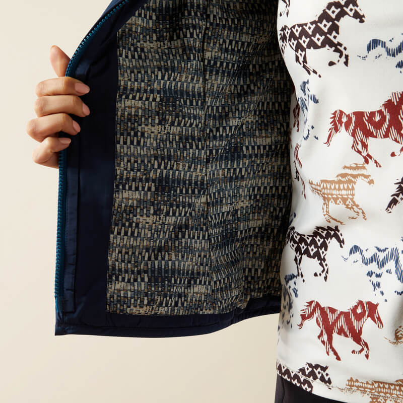 She opens her Ariat Ashley 2.0 Vest to reveal a blue lining, wearing Ariat equestrian apparel.