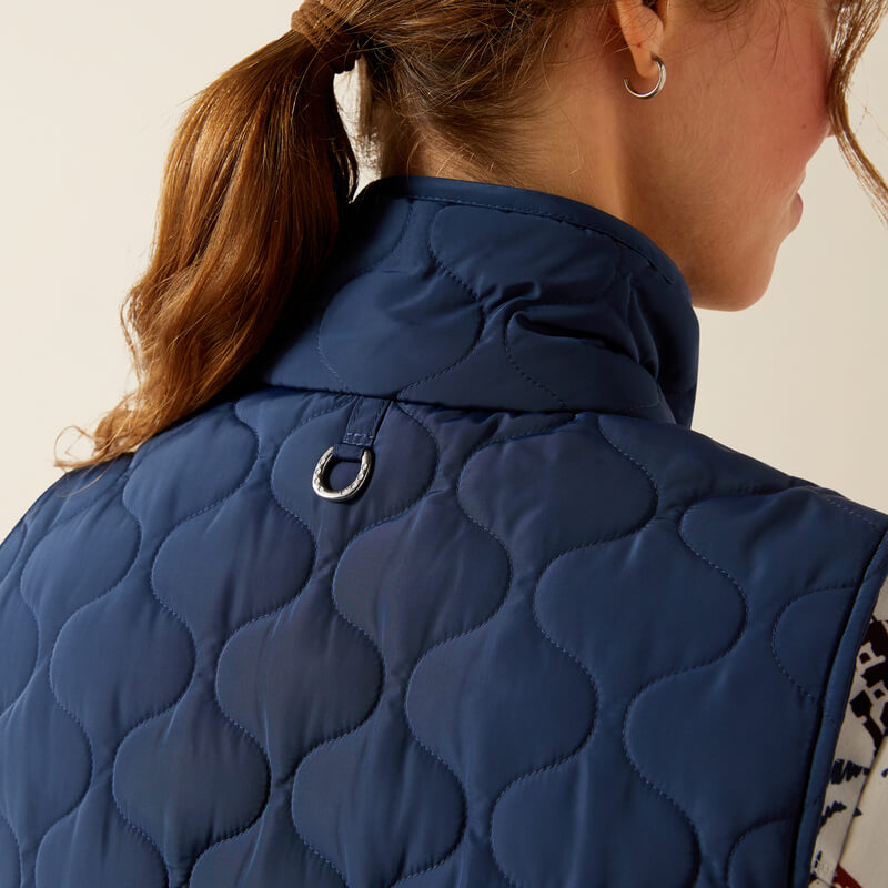 Woman in Ariat Ashley 2.0 Insulated Vest Big Dipper, blue, shown from the back with ponytail.