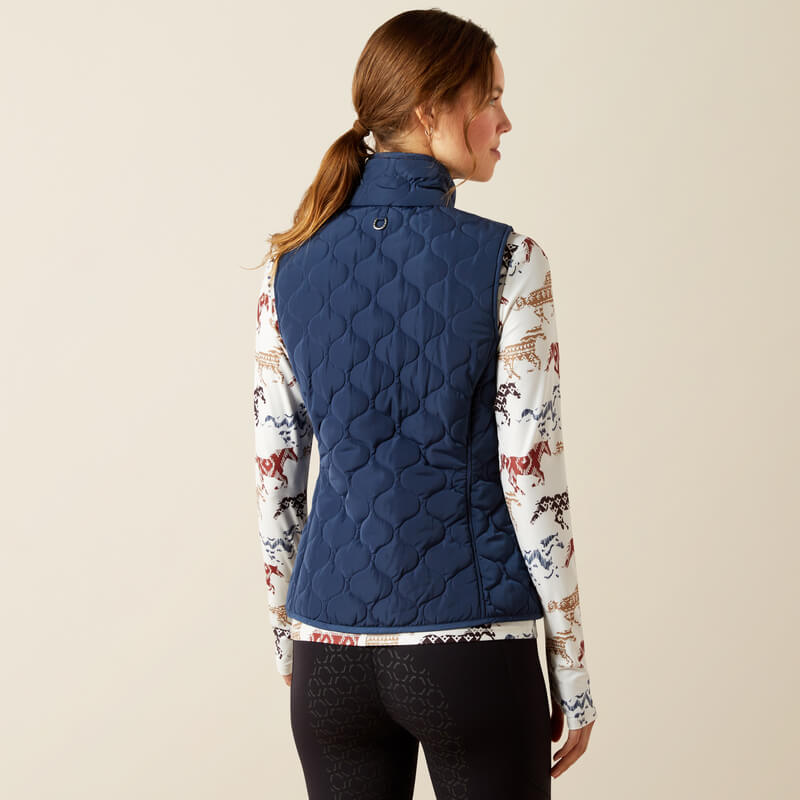 Woman in Ariat Ashley 2.0 Insulated Vest Big Dipper, printed long-sleeve top, back view.