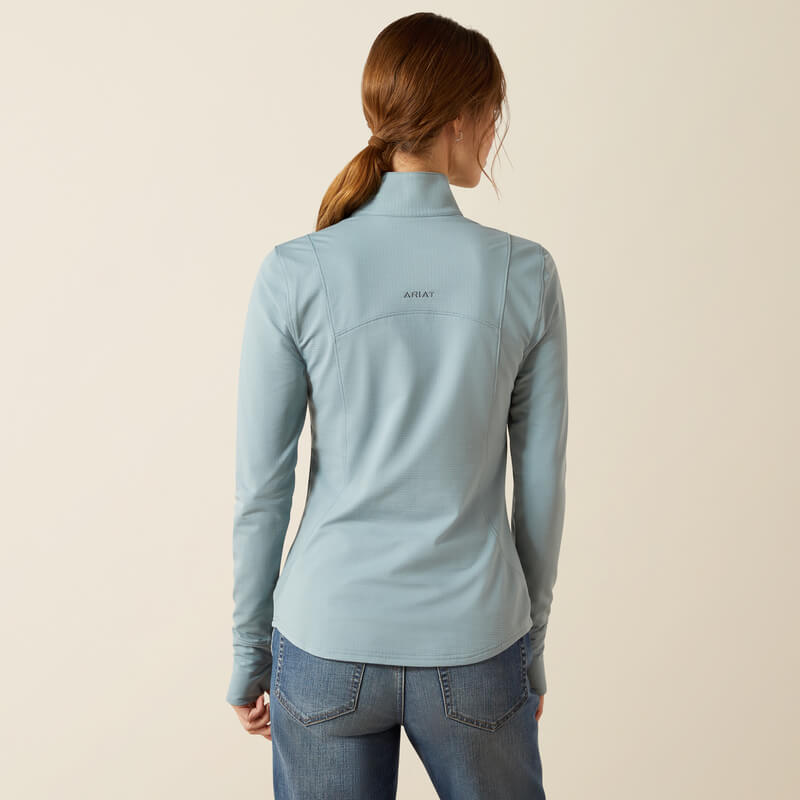 Woman in a lead Ariat Womens Gridwork 2.0 1/4 Zip Baselayer and jeans, shown from the back.