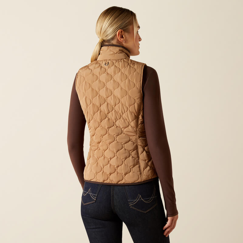 Woman in Ariat Women's Ashley 2.0 Insulated Vest Tiger's Eye and dark jeans, back view.