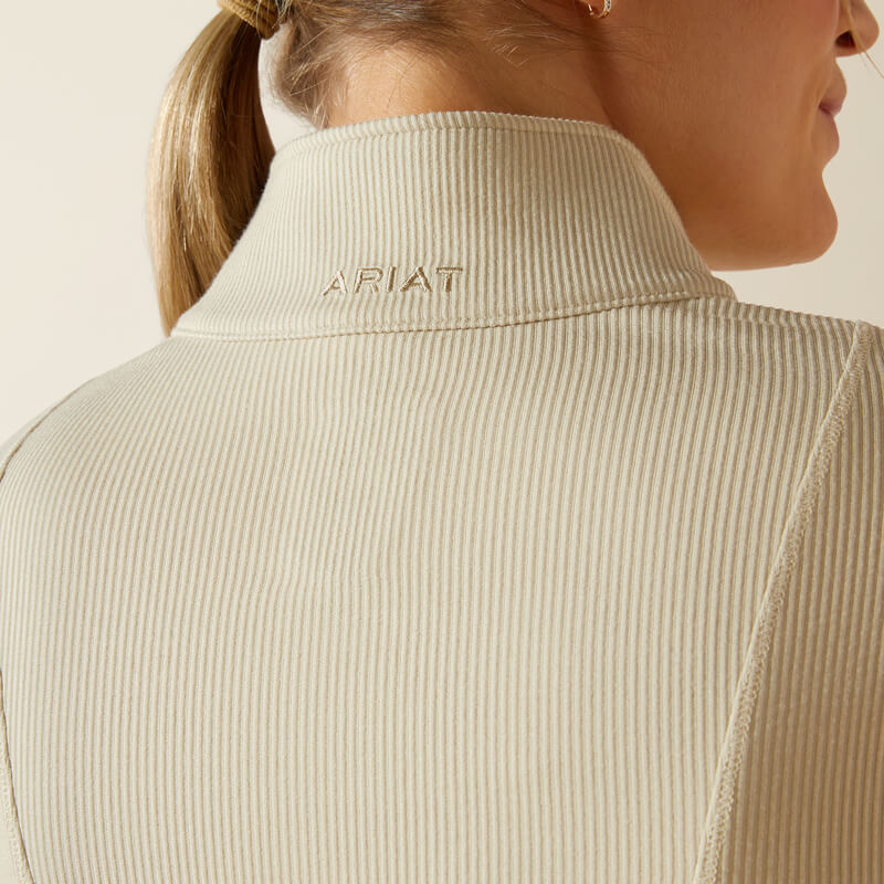Close-up of a woman in the Ariat Womens Lucent 1/4 Zip Baselayer Pelican with logo on collar.