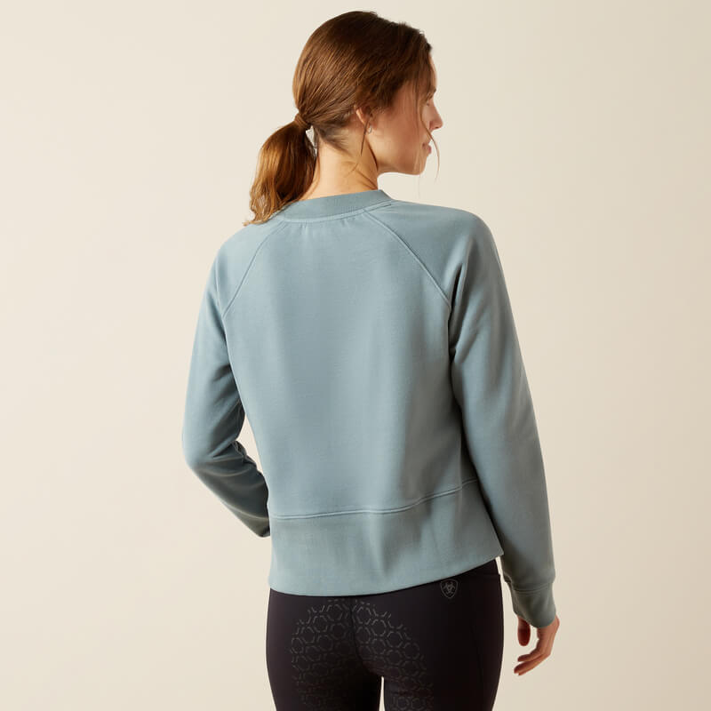 Woman with a ponytail wears an Ariat Womens Martine Sweatshirt Steel Sage, seen from behind.