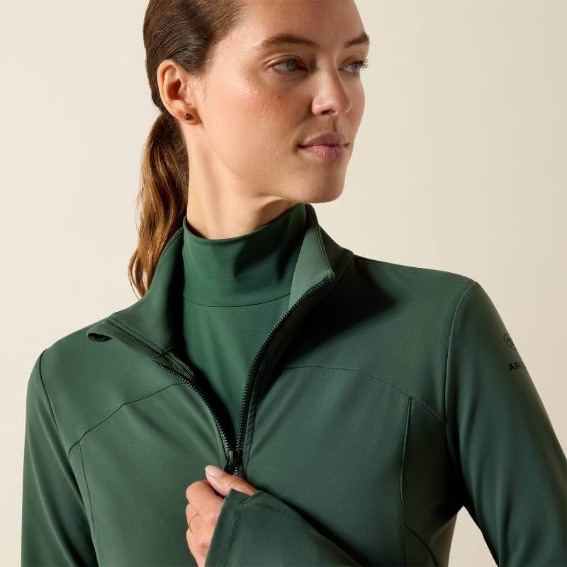 Woman in an Ariat Womens Solveil Full Zip Monstera jacket and leggings against a light background.