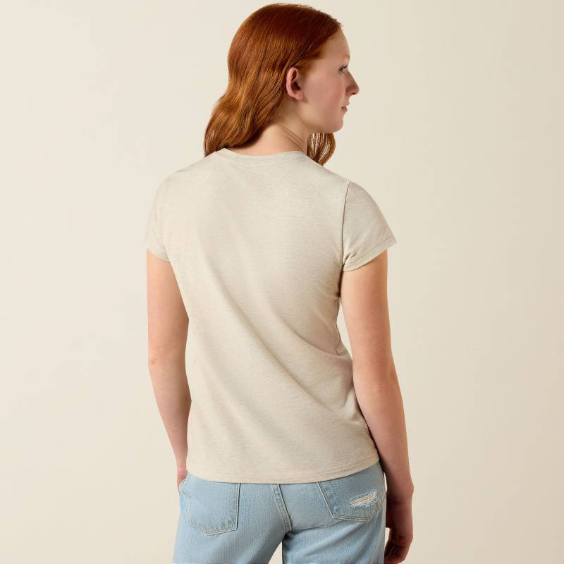 Girl with red hair in Ariat Youth Floral Leap SS T-Shirt Oatmeal, turned away from camera.