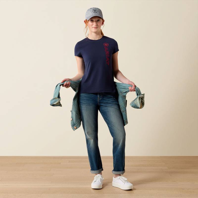 Person in a cap, Ariat Youth Vertical Logo SS T-Shirt Navy/Red, jeans, white shoes, denim jacket.