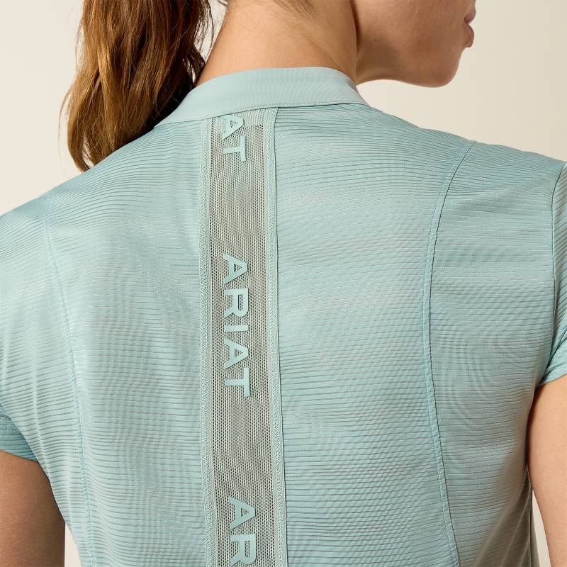 Woman in Ariat blue surf Breathe 1/2 Zip Cap Sleeve Baselayer with mesh panel and back logo.