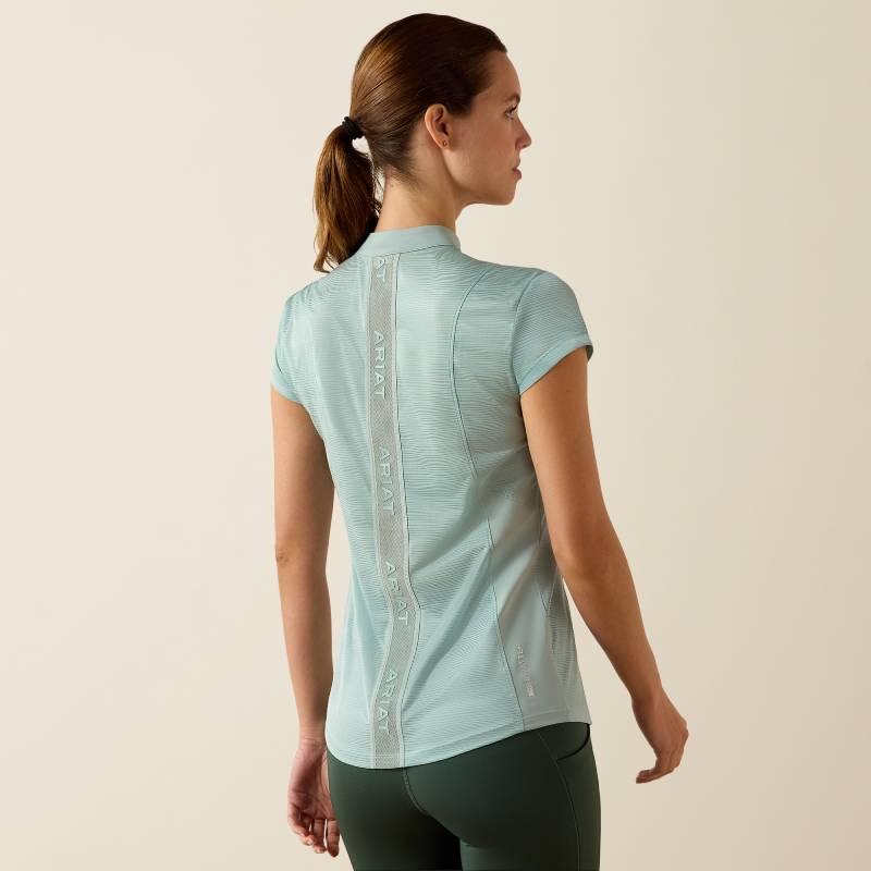 Woman in Ariat Breathe 1/2 Zip Cap Sleeve Baselayer, Blue Surf, faces away from the camera.