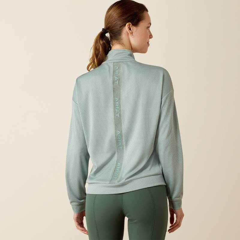 Woman in Ariat Breathe 1/2 Zip Pullover Chinois Green, back to camera.
