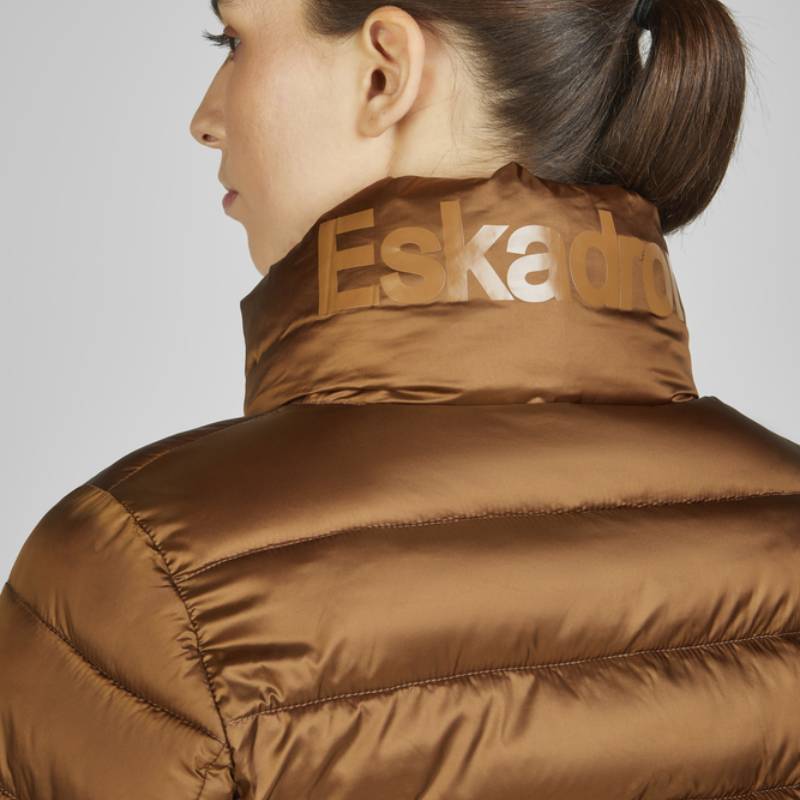 Woman in an Eskadron Heritage Quilt Jacket Almond, side view, with Eskadron text on the collar.