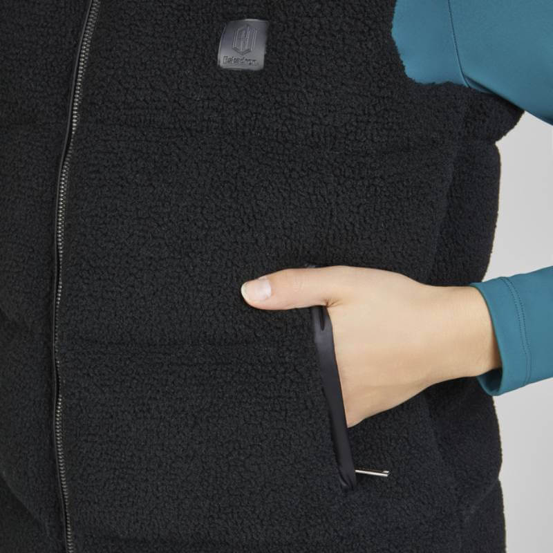 Hand in pocket of Eskadron Heritage Quilt Waistcoat Teddy Black over teal long-sleeve shirt.