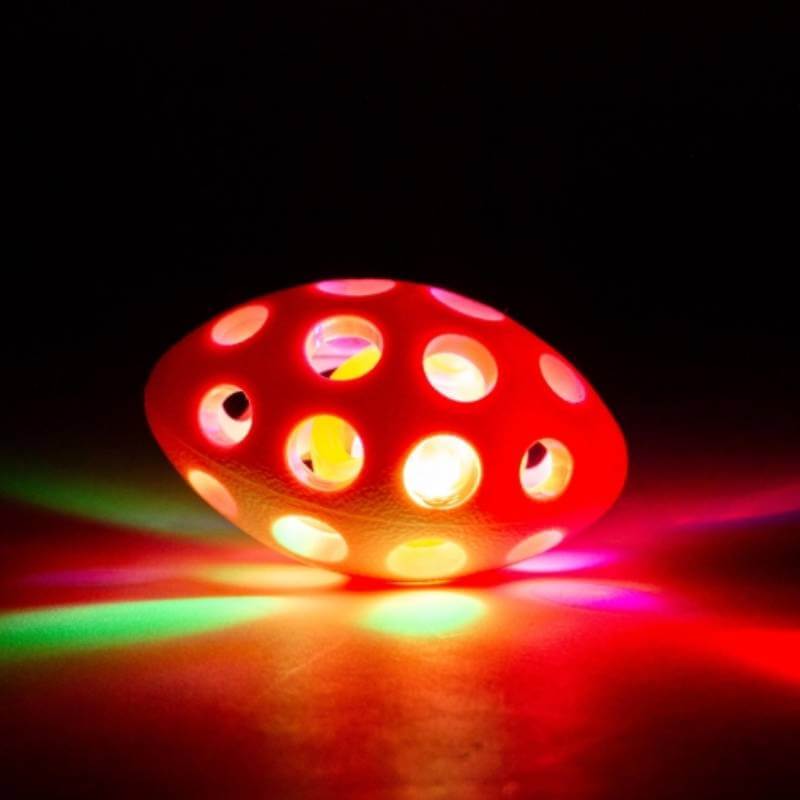Ancol Small Bite Flashing Rugby Ball glows with colorful lights and is shaped like an egg.