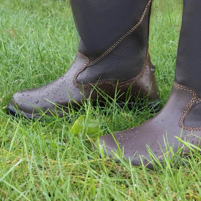Hy Equestrian Hy Tideswell Country Boots Childs Brown stand on wet green grass.