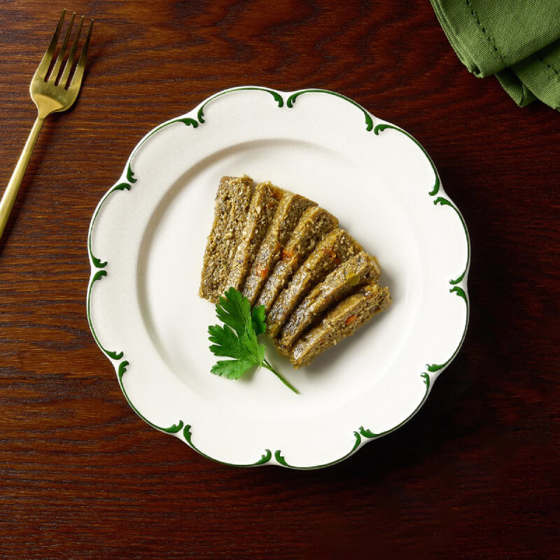 Canagan Petite MSC Cod & Herring Pate for Dogs 100g on a white plate, gold fork nearby.