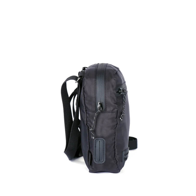 Side view of Mountain Paws Dog Snack Pack, a black crossbody pouch with strap and poo bag dispenser.