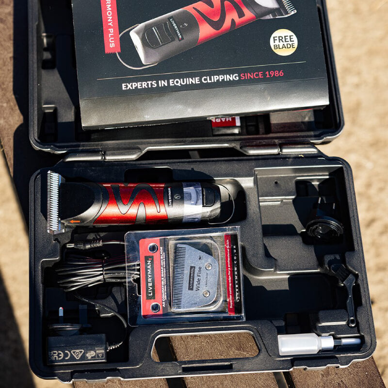Open case with Liveryman Clipper Harmony Plus Anniversary Pack and accessories on wood surface.