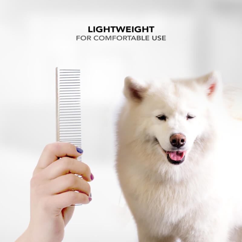 Hand holding Wahl 15cm Stainless Steel Coarse Comb near a fluffy white dog, lightweight and comfy.
