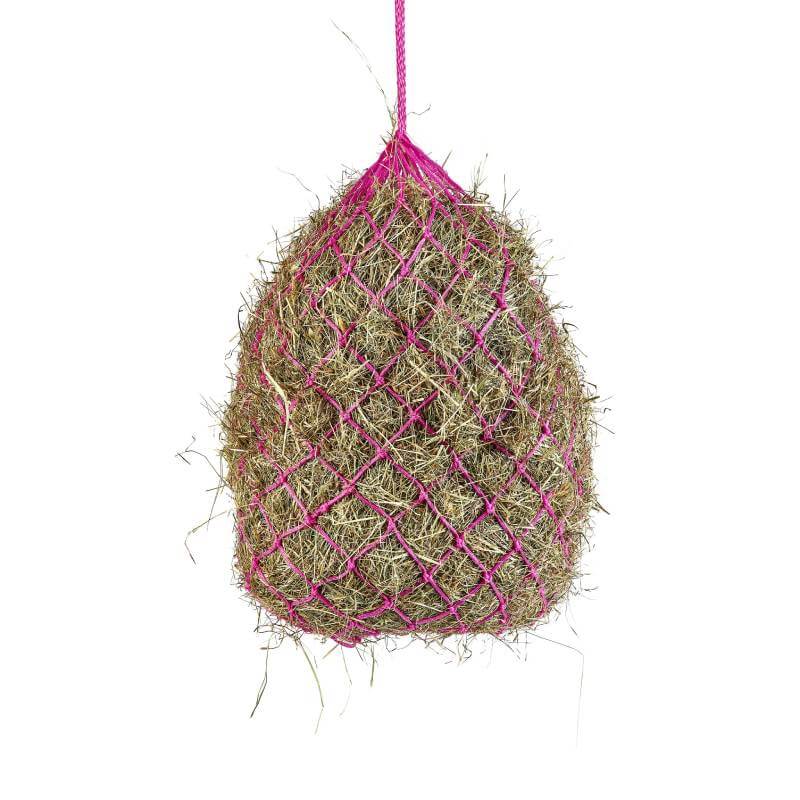 A Shires Haylage Net in pink fine mesh, filled with hay and hanging by a rope.