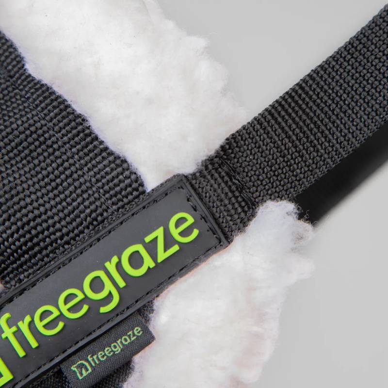 Close-up of Shires FreeGraze Deluxe Comfort Grazing Muzzle with "freegraze" on white fleece.