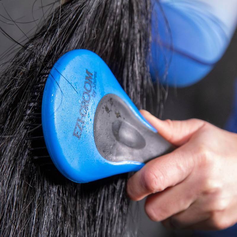 Brushing wet black hair with a Shires Ezi Groom Grip Mane & Tail Brush in Bright Blue.