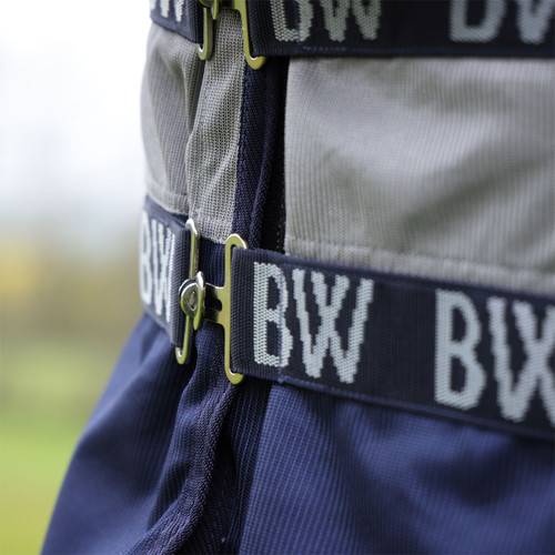 A horse in a Shires Bridleway Metabug Combo Neck Fly Rug Grey stands on grass.