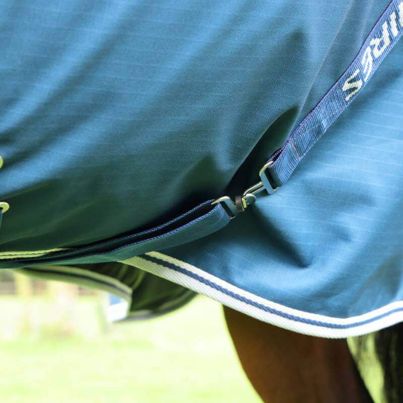 Close-up of Shires Highlander 50g Ocean turnout rug with metal fasteners and striped trim.